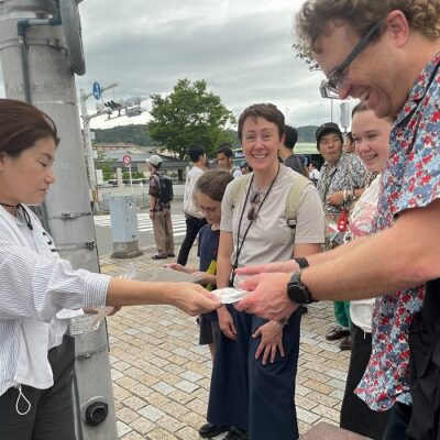 沿道の観光客に折り鶴を渡しアピール